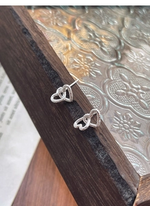 Detailed close-up of S925 silver double heart earrings with unique hammered texture surface