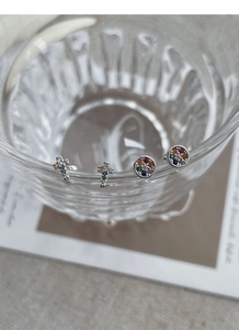 Macro shot of S925 silver stud earrings set with colorful cross and round zircon gems