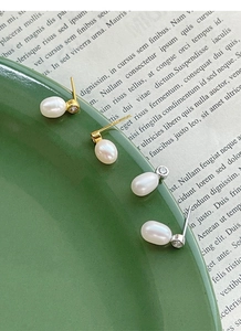 Détail de boucles d'oreilles en perles argent et or avec zircon sur plat céramique
