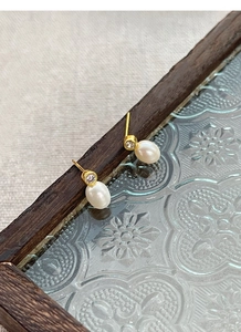Détail de boucles d'oreilles en argent S925 avec perle d'eau douce et petit diamant