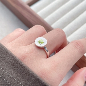Bague en argent sterling S925 avec zircon vert texturé sur un plateau à bijoux en bois