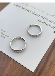 Close-up of frosted S925 sterling silver couple rings with sparkling sand texture finish