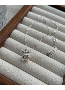 Makroaufnahme einer Halskette aus S925 Sterling Silber mit Schleifen-Perlenanhänger