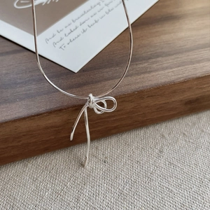 Minimalist S925 sterling silver bow knot pendant necklace on a sleek snake chain