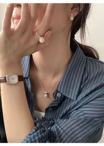 Detail of S925 silver pearl jewelry set worn with a vintage gold square watch