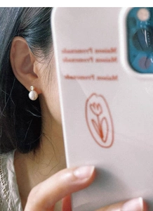 Gros plan d'une élégante boucle d'oreille en perles d'eau douce portée par un modèle