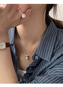 Elegant S925 silver gold-plated pearl necklace and ring set worn on a female model