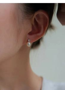 Gros plan d'une boucle d'oreille en argent S925 avec perle d'eau douce et un zircon