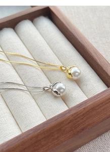 Detailed macro of gold and silver S925 sterling silver necklaces with elegant pearls