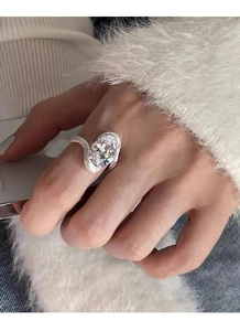 Gros plan sur bague en argent S925 avec zircon ovale et anneau texturé aux formes ondulées