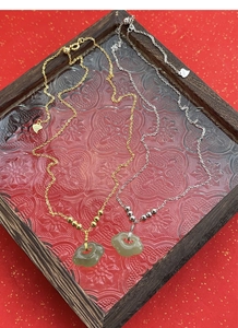 Gros plan sur le poinçon argent S925 du collier serrure Ruyi en jade rétro pour femme