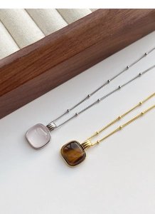 Detailed close-up of square cushion-cut rose quartz and tiger eye pendants on dainty chains
