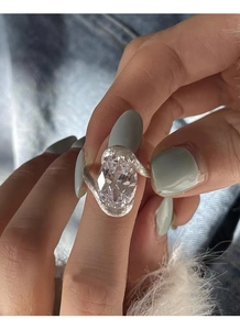 Gros plan sur bague en argent avec zircon ovale et détails de l'anneau texturé croisé