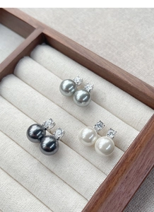 Detailed macro view of S925 silver pearl earrings with zircon in grey and white tones