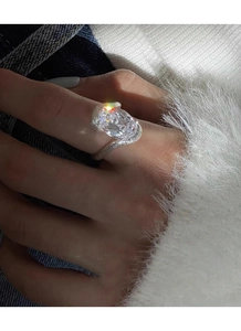 Gros plan d'une bague avec zircon ovale étincelant et finition en argent brossé