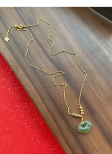 Détail du collier en argent S925 doré avec pendentif Ruyi en jade vert et tag S925