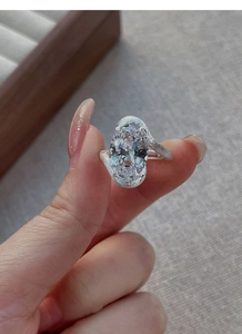 Gros plan de la bague en argent avec zircon aurore et finition mate élégante sur l'anneau