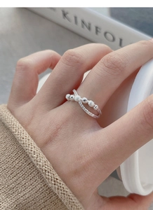 Close-up of S925 sterling silver crisscross ring with beads and crystals on hand