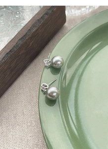 Detailed macro view of S925 silver stud earrings with grey pearls and clear zircon