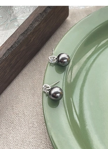 Detail of dark grey pearl earrings with S925 silver stamp and sparkling cubic zirconia