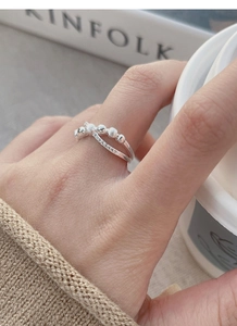 Close-up of double-layered silver ring with textured metal beads and tiny zircon accents