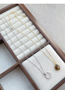 Detailed macro view of S925 sterling silver square tiger eye and pink quartz necklaces