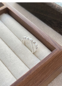 Macro detail of S925 sterling silver double-layer cross ring with zircons and silver beads