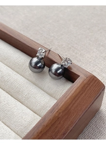 Close-up of elegant black pearl stud earrings with zircon inlay on S925 silver