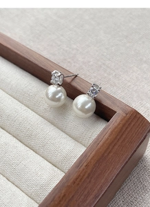 Macro shot of S925 sterling silver stamp on pearl earrings with cubic zirconia