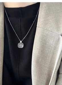 Detail shot of a minimalist square translucent stone pendant on a silver beaded chain