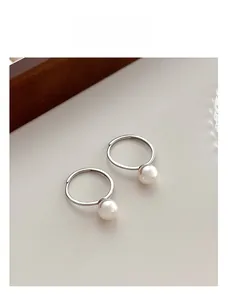 Gros plan de bagues en perles minimalistes en argent S925 sur surface beige