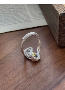 Détail de bague en argent S925 avec zircon ovale sur bois dans un décor vintage chic
