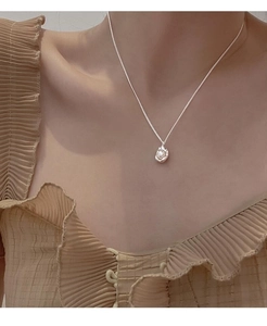 Detailed view of an S925 silver necklace with a white pearl in a lava-textured setting
