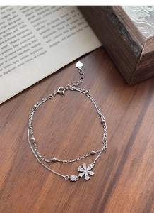 Detailed macro view of S925 silver double-layer bracelet with zircon flower charm