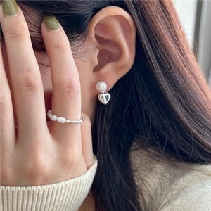 Close-up of S925 sterling silver ring with elegant freshwater pearls on a female finger