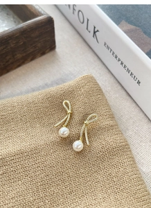 Detailed macro view of S925 silver bowknot earrings with sparkling stones and white pearl