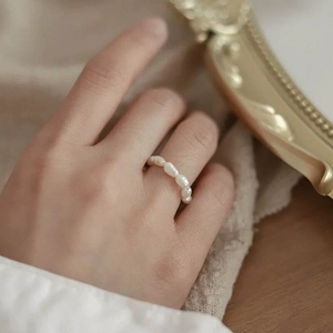 Close-up of S925 silver ring with natural baroque pearls on vintage background
