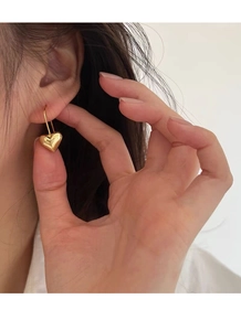 Primo piano di orecchini a cuore in argento S925 placcato oro con finitura lucida