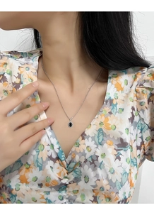 Close-up of elegant S925 silver necklace with black oval gemstone on woman neck