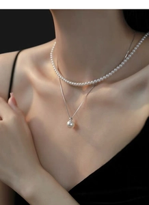Close-up of double-layered S925 silver necklace with white pearls on a model neck