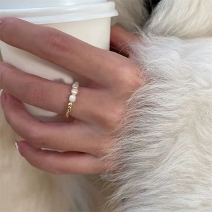 Detail of three freshwater pearls set on a gold adjustable minimalist ring band