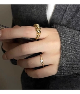 Macro shot of gold croissant dome ring paired with minimalist cubic zirconia silver ring