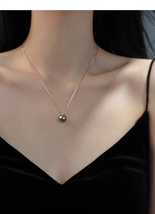 Close-up of minimalist S925 sterling silver pearl pendant necklace on model's neck