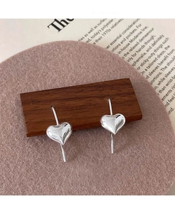 Vista dettagliata di orecchini a cuore in argento sterling S925 con finitura lucida