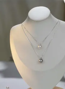 Detailed shot of S925 silver necklaces with premium white and grey pearls on a display