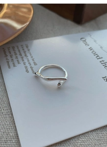 Detailed view of an S925 sterling silver irregular vine ring on a minimalist background