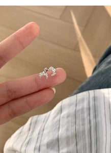 Macro detail of S925 sterling silver croissant stud earrings with secure screw back design