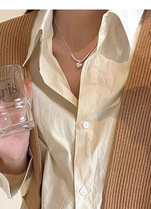 Close-up of minimalist S925 sterling silver heart necklace worn by a model