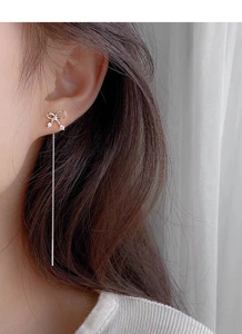 Close-up of S925 sterling silver bow tassel earrings with sparkling rhinestones