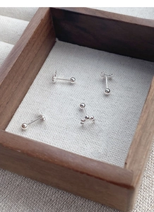 Detail of S925 sterling silver croissant screw back earrings on a wooden display tray